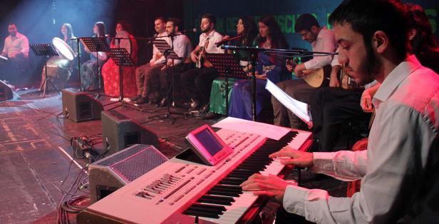 Eine Musikgruppe tritt auf einer Bühne mit verschiedenen Instrumenten auf.