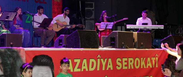 Eine Musikgruppe tritt auf einer Bühne vor einem Publikum auf.