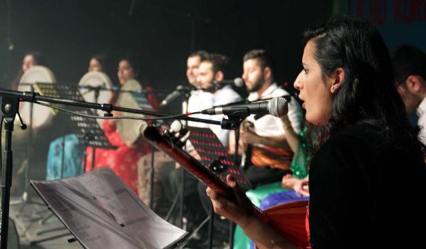 Eine Sängerin tritt mit ihrer Band auf einer Bühne auf.