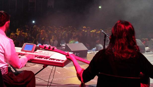 Zwei Musiker treten vor einem Publikum auf einer Bühne auf.