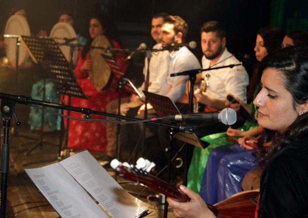 Eine Musikgruppe tritt mit traditionellen Instrumenten auf einer Bühne auf.