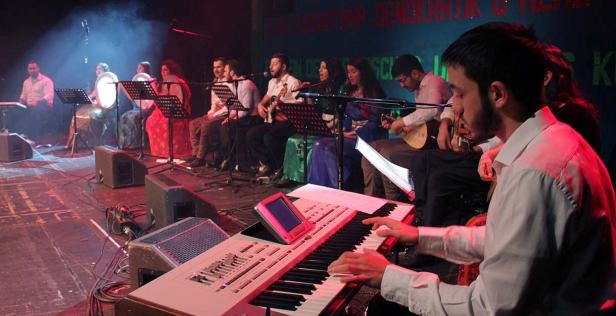 Eine Gruppe von Musikern tritt auf einer Bühne mit verschiedenen Instrumenten auf.