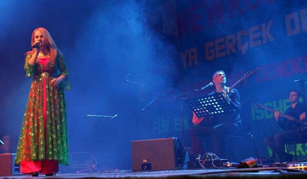 Eine Sängerin tritt mit ihrer Band auf einer Bühne auf.