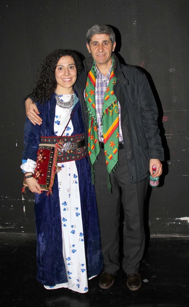 Eine Frau in traditioneller kurdischer Kleidung posiert mit einem Mann für ein Foto.