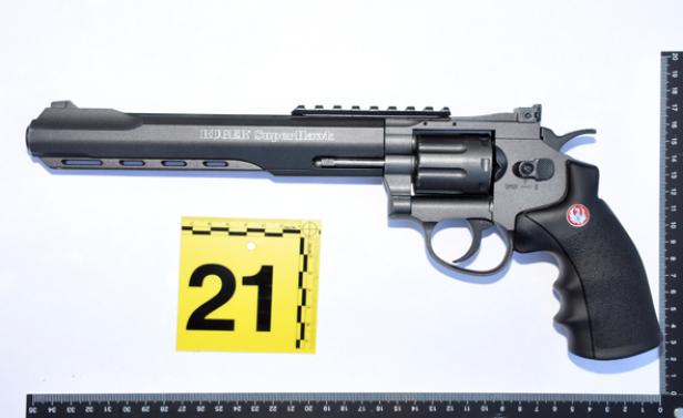 Ein grauer Revolver der Marke Ruger Superhawk liegt auf einem weißen Untergrund.