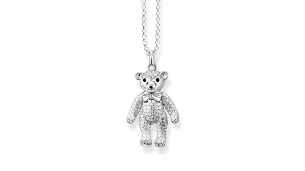 Eine Halskette mit einem Teddybär-Anhänger, der mit glitzernden Steinen besetzt ist.