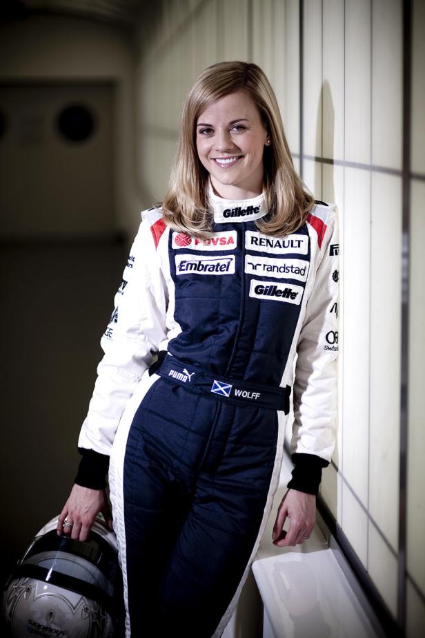 Die Rennfahrerin Susie Wolff in Rennkleidung mit Helm in der Hand.