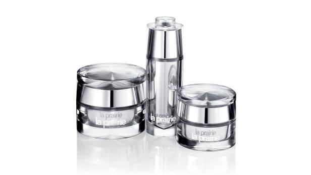 Drei silberfarbene Hautpflegeprodukte von La Prairie stehen auf einem weißen Hintergrund.