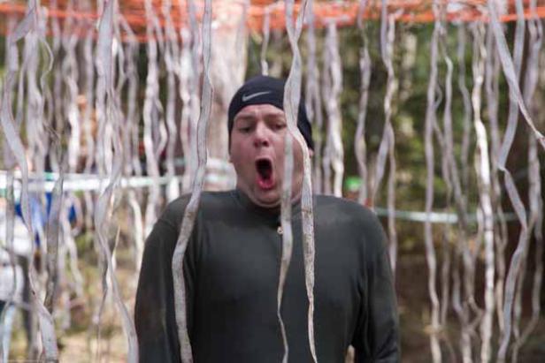 Ein Mann mit offenem Mund steht vor einem Hindernis aus Bändern.