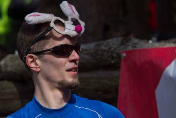 Ein Mann mit Sonnenbrille und Hasenohren-Stirnband blickt zur Seite.