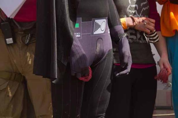 Eine Person in einem Kostüm, möglicherweise Darth Vader, steht neben anderen Personen.