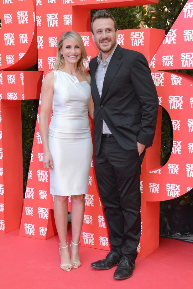 Cameron Diaz und Jason Segel posieren vor einer Wand mit dem Schriftzug „Sex Tape“.