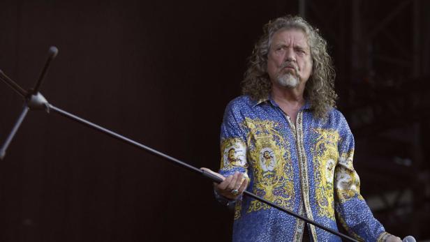 Robert Plant von Led Zeppelin hält ein Mikrofon auf der Bühne.