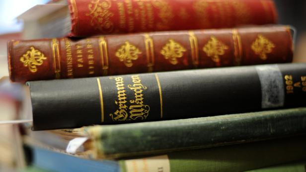 Ein Stapel alter Bücher, darunter eine Ausgabe von „Grimms Märchen“.