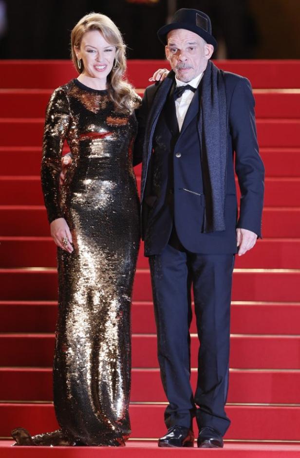 Kylie Minogue und Leos Carax posieren auf einem roten Teppich.