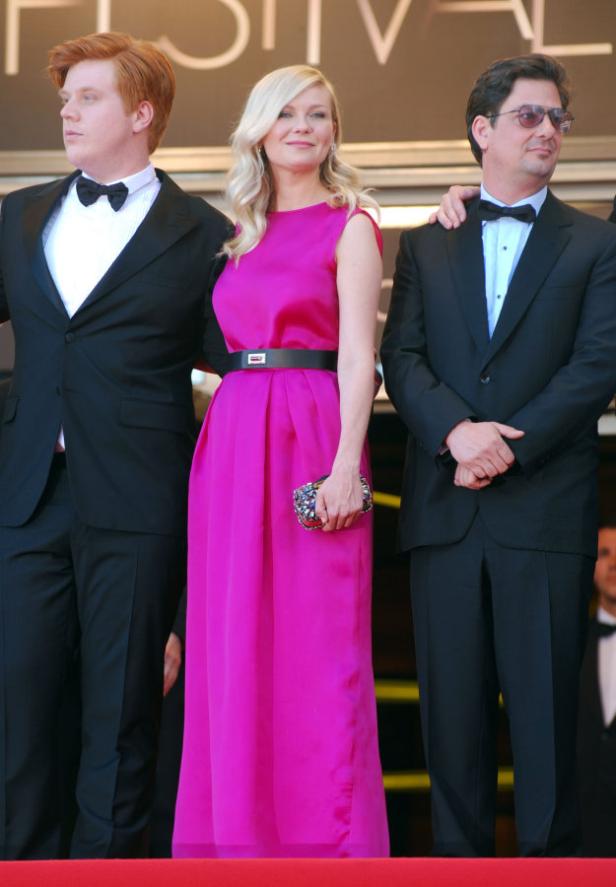 Kirsten Dunst mit Jesse Plemons und einem weiteren Mann auf dem roten Teppich.