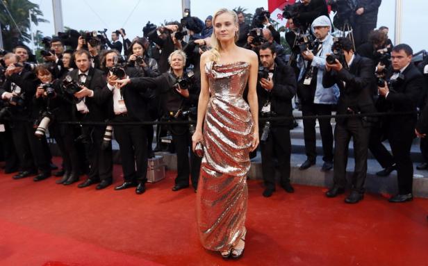 Diane Kruger posiert auf dem roten Teppich, umgeben von Fotografen.