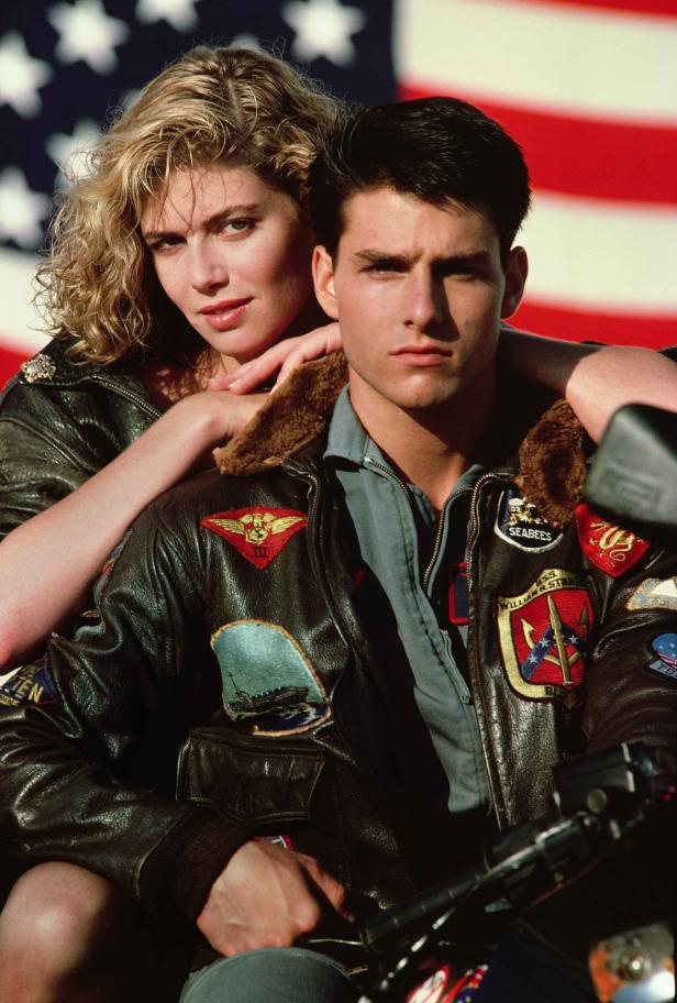 Tom Cruise und Kelly McGillis vor einer US-Flagge im Film „Top Gun“.