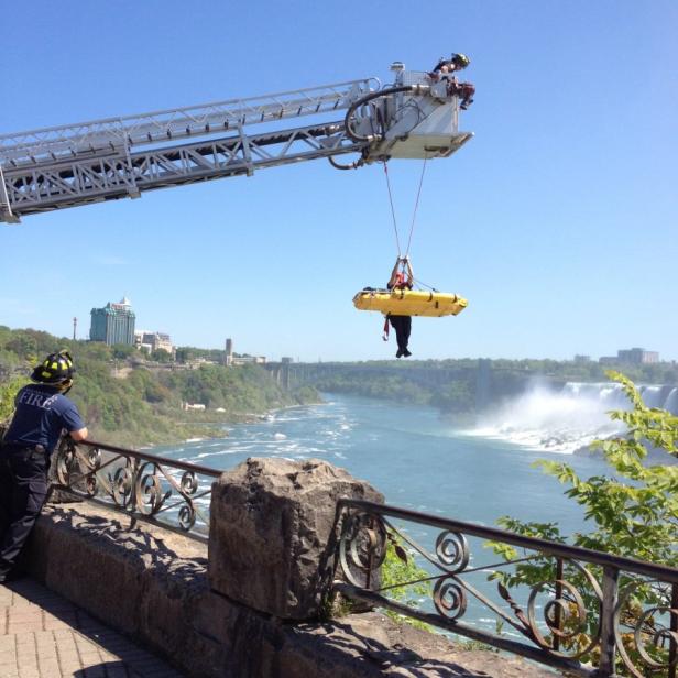Ein Feuerwehrmann wird mit einer Trage vor den Niagarafällen in Sicherheit gebracht.