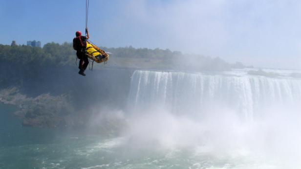 Ein Rettungssanitäter seilt sich mit einer Trage vor den Niagarafällen ab.