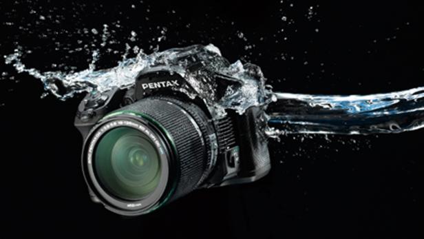 Eine Pentax-Kamera wird von Wasser umspült.
