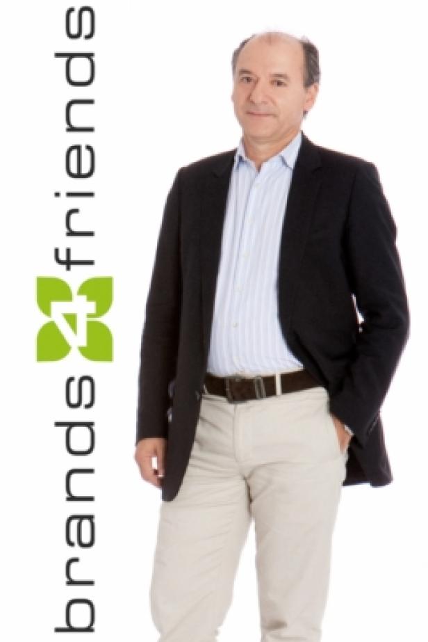 Ein Mann in einem dunklen Sakko und hellen Hosen steht neben dem Logo „brands4friends“.