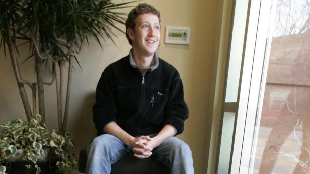 Mark Zuckerberg sitzt in einem Sessel und lächelt aus dem Fenster.