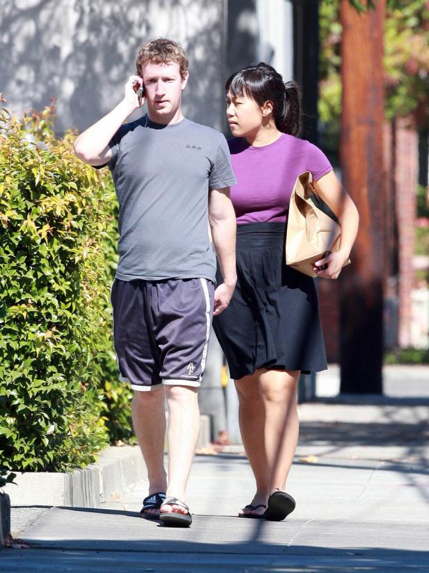Mark Zuckerberg und Priscilla Chan gehen zusammen auf dem Bürgersteig entlang.