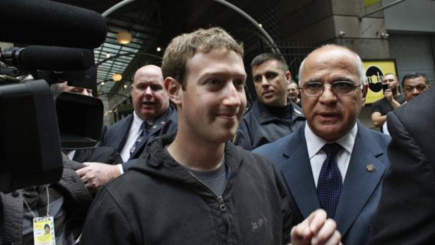 Mark Zuckerberg umgeben von Reportern und Sicherheitsleuten.