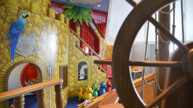 Ein fantasievoller Spielbereich mit Burgmotiven, einem Piratenschiff-Steuerrad und bunten Details.