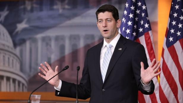 Paul Ryan spricht vor amerikanischen Flaggen.