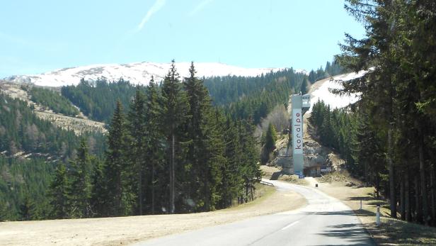Eine Straße führt zur Koralpe, einem Berggebiet mit Skipisten und Wäldern.