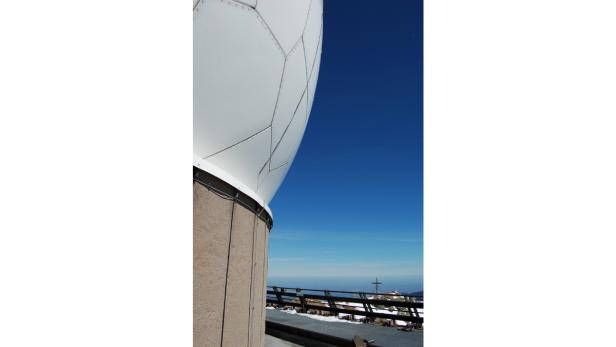 Eine Radarkuppel auf einem Berg mit Blick auf eine Landschaft.