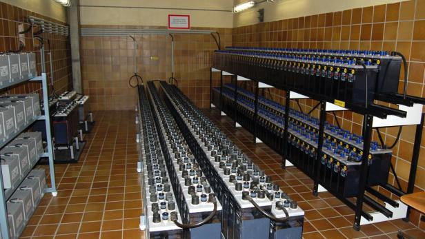 Ein Raum mit langen Reihen von Batterien auf Regalen und auf dem Boden.