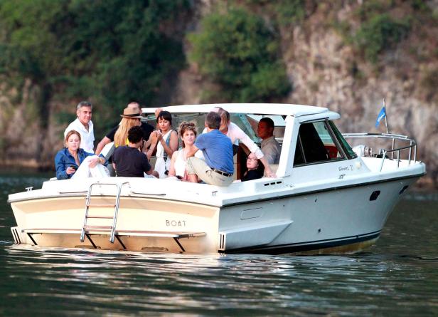 Eine Gruppe von Menschen fährt mit einem Motorboot auf einem See.