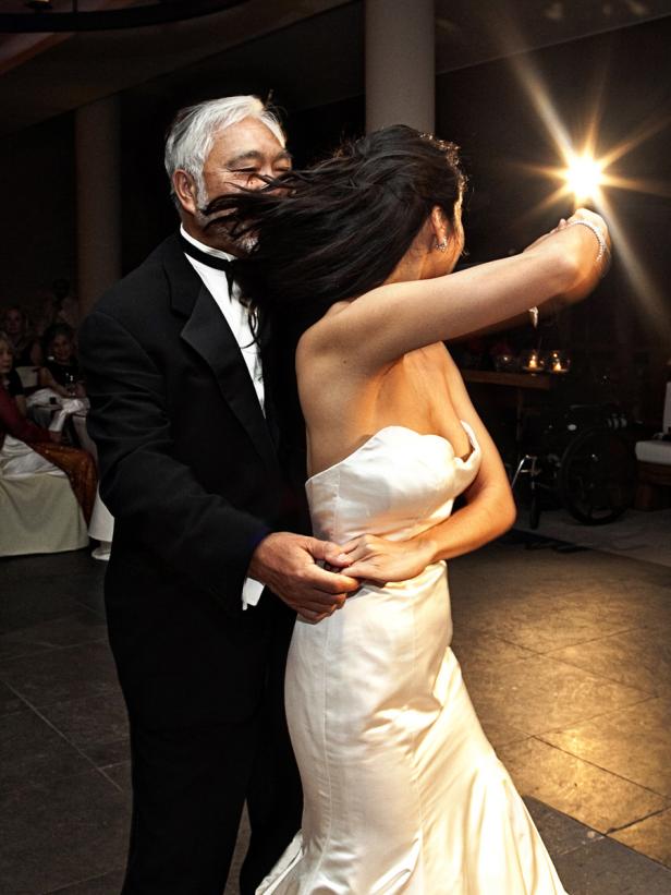 Eine Braut tanzt mit einem älteren Mann, vermutlich ihrem Vater, auf ihrer Hochzeit.