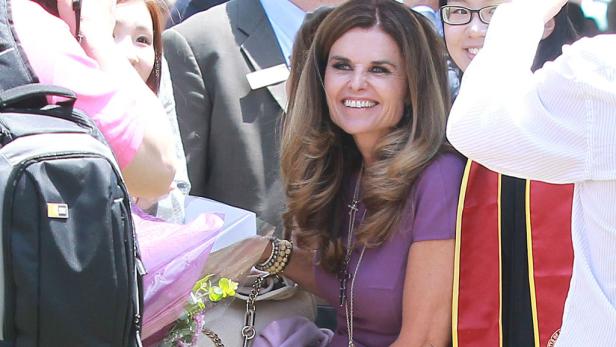Maria Shriver lächelt umgeben von Menschen bei einer Abschlussfeier.