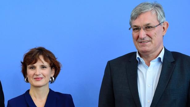Eine Frau und ein Mann stehen vor einem blauen Hintergrund.
