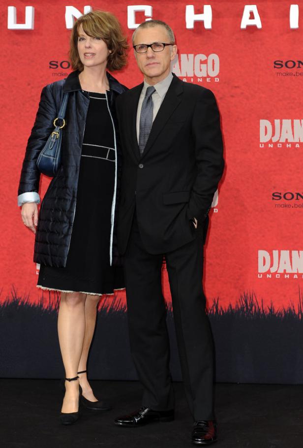 Christoph Waltz und seine Frau posieren vor einem „Django Unchained“-Poster.