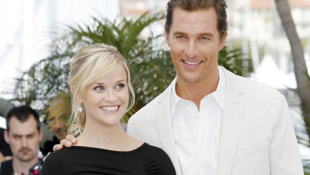 Reese Witherspoon und Matthew McConaughey posieren lächelnd nebeneinander.
