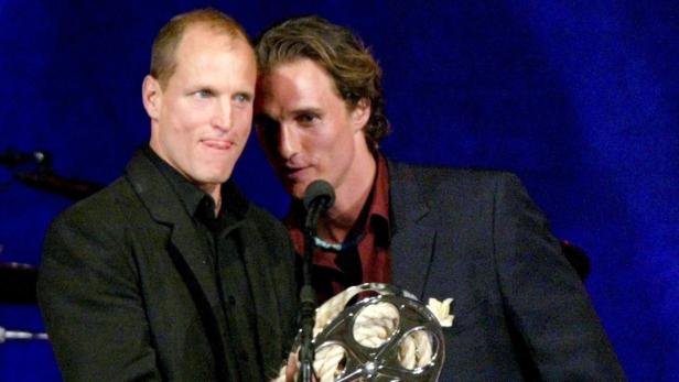 Matthew McConaughey und Woody Harrelson halten eine Auszeichnung in Form einer Filmrolle.