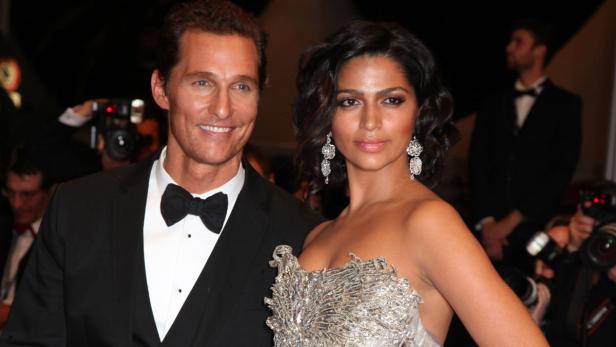 Matthew McConaughey und Camila Alves posieren auf einem roten Teppich.