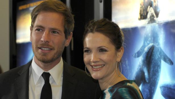 Drew Barrymore und Will Kopelman posieren vor einem Filmposter.