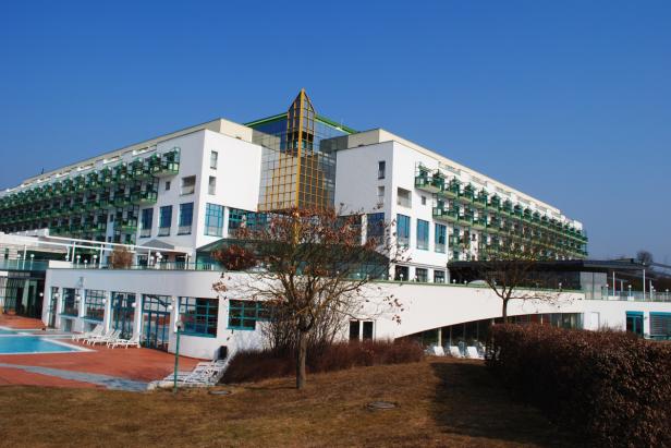 Ein großes, weißes Hotel mit vielen Balkonen unter blauem Himmel.