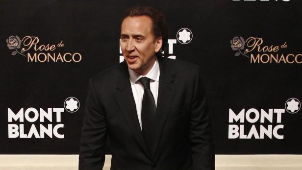 Nicolas Cage posiert vor einem Hintergrund mit „La Rose de Monaco“ und Montblanc-Logos.