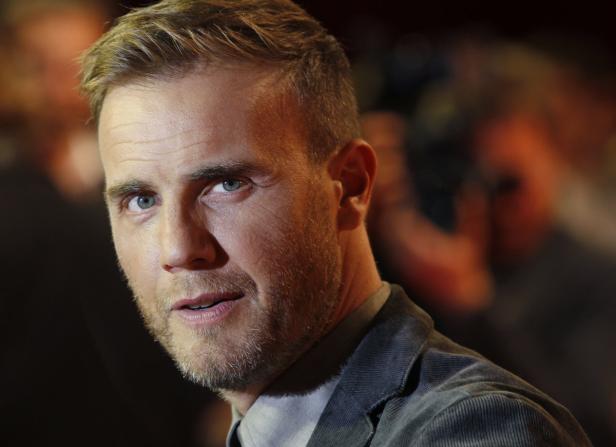 Porträt von Gary Barlow mit blau-grauen Augen und Bartstoppeln.