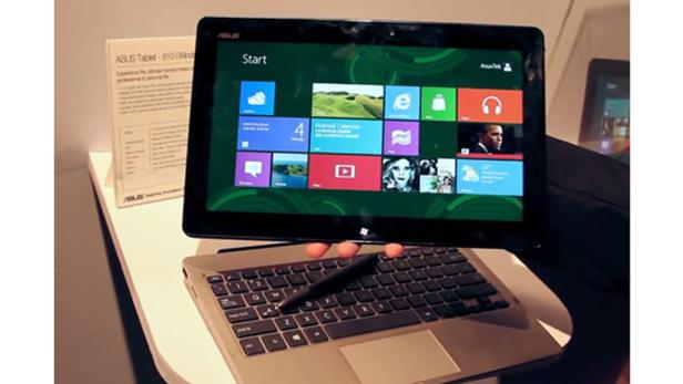 Ein Asus-Tablet mit Windows-Startbildschirm ist an eine Tastatur angeschlossen.