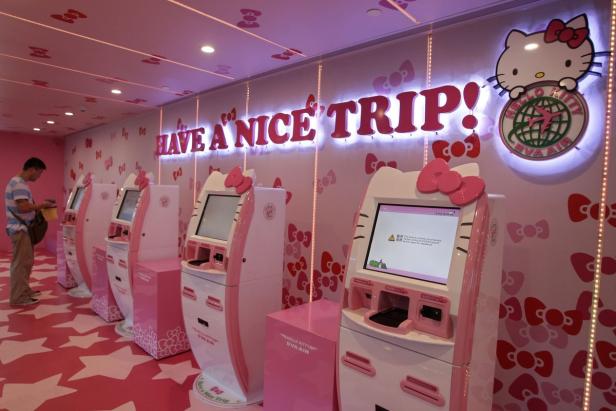Ein Hello Kitty-Themenbereich mit Check-in-Automaten von EVA Air und der Aufschrift „Have a nice trip!“.