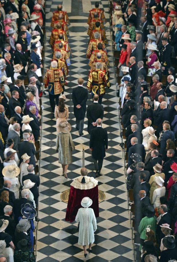 Eine Menschenmenge in einer Kirche mit schwarz-weiß kariertem Boden.