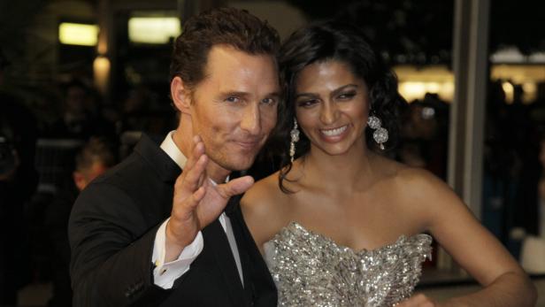 Matthew McConaughey und Camila Alves posieren lächelnd auf einem Event.